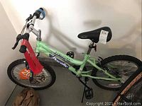 Side angle of green ByVortex Evolution bike showing frame, seat, handlebars, and wheels.