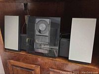 Front view of central unit flanked by two speakers on wood cabinet