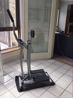 Full view of elliptical machine on floor mat showing overall condition and setup.