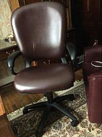 Front-side view of the brown Hon office chair with cushioned seat and backrest, black armrests, and five-wheel base on carpet.
