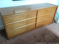 Front view of mid-century style wooden dresser with six horizontal drawers.