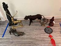 Wide view of all figurines and sculptures arranged on the floor showing size and relative positioning