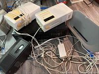 Photo showing Nakamichi TM-1 and TM-2 clock radios, Denon DRW 660 cassette player, Phillips DS8500 speaker dock, and cables on floor.