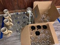 Photo showing 4 Strohs beer steins, 8 Lowenbrau glass mugs, 1 Getz beer stein, metal flask, and 2 cardboard boxes containing martini and cordial glasses