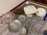 Overview photo of all plates, platters, and bowls on table showing shapes and designs.