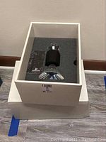 Swarovski crystal candle holder displayed in original white box with foam insert on a wooden floor.