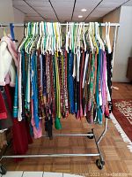 Clothing rack displaying over fifty saris on plastic hangers in various colors and prints