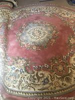 Round Oriental rug displayed flat showing overall design and colors with floral border and central medallion.