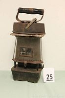 Cast iron kerosene oil heater stove with sad iron on top, showing overall condition and scale with lot number.