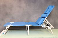 Side profile view of the chaise lounge chair fully extended showing blue fabric seat and backrest with white metal frame and adjustment notches.