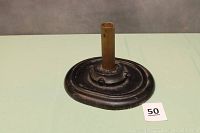 Full view of the cast iron flag holder with oval base and vertical pole holder.