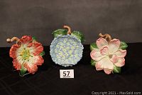 Three Fitz & Floyd Essentials floral plates arranged side by side, showing dogwood, blue hydrangea, and pink blossom flowers each about 8 inches in diameter with stems.