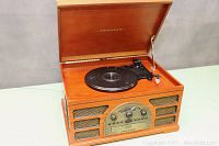 Front view of opened Crosley vintage style record player showing turntable with tonearm and needle.