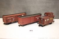 Wide view of all three cars - caboose, box car, and reefer, all brown with Pennsylvania markings