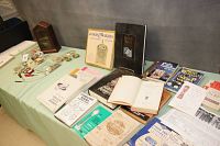 Overview of books related to clock and watch repair spread out on a table, some open.
