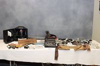 Wide view of entire lot showing various tools, cords, chain saw, socket sets, and handheld tools spread over a table