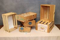 Group photo of 4 wooden crates, 3 smaller with blue and green Table Grape advertising, 1 larger with lemon advertising.