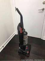 Photo of upright Bissell PowerTrak vacuum cleaner with transparent dust container and ergonomic handle.
