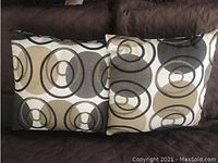 Two square pillows featuring the abstract circular design in neutral tones arranged side-by-side showing the front face.
