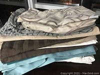 Stack of assorted pillow cases showing various colors and patterns in detail.