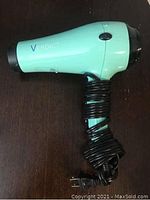 Side view of turquoise Verdict hair dryer with black cord wrapped around handle.