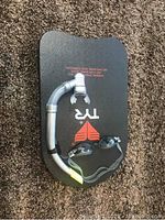 Photo of black swim kickboard laying on carpet with an attached snorkel and placed swimming goggles.