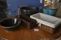 Full view of six baskets arranged on table showing variety of materials and styles