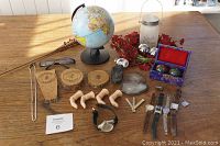 Photo showing entire collection of small items including globe, lantern, orchids, Baoding balls, finger hooks, watches, wooden items, geode, sunglasses, and others.
