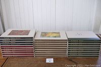 Full set of 28 Time-Life Library of Art books arranged in three stacks by color-coded binding and dust jacket style, visible titles showing artists like Picasso, Matisse, Leonardo, and more.