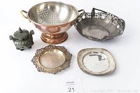 All five items grouped together on white background: copper colander, metal bread basket, butter dish, plate, and stone incense dish.