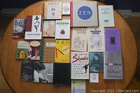 Full view of the collection spread on a round table, showing multiple books from various religious and philosophical traditions including Buddhism, Confucius, and critiques of religion.