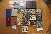 Photo showing all books laid out on a wooden table, depicting condition and titles.