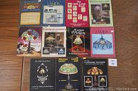 Photo showing all 11 lamp making books with colorful covers laid out on a wooden surface.