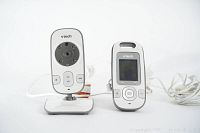 Photo of VTech camera unit and parent monitor showing front view, camera lens with night vision LEDs, and screen on monitor.