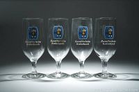 Set of four Sandlerbräu Kulmbach vintage pilsner beer glasses with colorful logos and text.