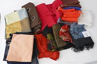 Lot contents showing curtains, scarves, and folded fabrics in various colors and textures.