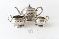 Full view of the vintage Wm Rogers silver plated tea set including teapot, creamer, sugar bowl with spoon displayed on white background.