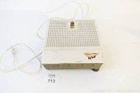 Front angled view showing entire grinder with perforated work surface, base, grinding bit, and power cord.