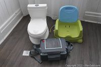 Full view of the lot showing the mini white potty, green booster seat with blue backrest, and gray Nuby travel booster seat on floor