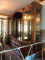 Full view of display cabinet showing wood finish, glass doors, and multiple drawers.