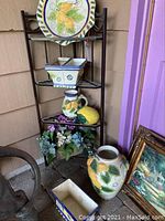 Full view of shelf holding ceramic set including platter, planters, pitcher, lemon and flower basket