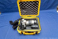 Open yellow hard case containing silver Pentax MZ-50 camera with attached 80-320mm lens and a black 35-80mm lens