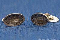 Front view of the oval cufflinks showing the darkened embossed geometric design.