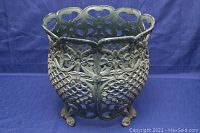 Side view showing floral and geometric lattice pattern, curved feet, and green paint with wear.