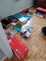 Various office supplies, boxes, papers, binders, tape dispenser, baskets on floor