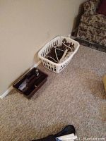 The lot shown in a room on carpeted floor with power bars and extension cords in a white plastic laundry basket, and an adjacent small brown organizer bin containing smaller electrical accessories.