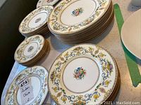 Overview of stacked plates showing floral and gold detailing typical of Minton China