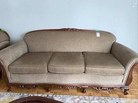 Front view of the full sofa showing the upholstery and wooden frame design.