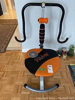 Front view of AB Doer Twist exercise machine showing padded seat with logo and attached CD on seat