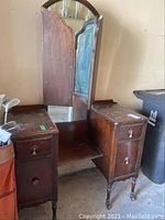 Front view of antique wooden dresser showing two drawer sections and attached mirror.